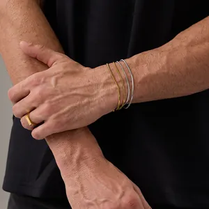 Vista dettagliata di bracciali a catena serpente a strati e un anello a sigillo lucido