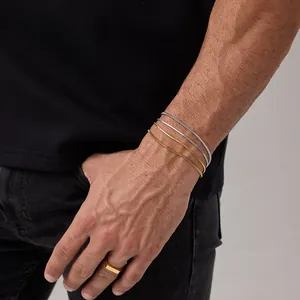 Macro di bracciali a catena a serpente dorati e anello a sigillo lucido sul polso