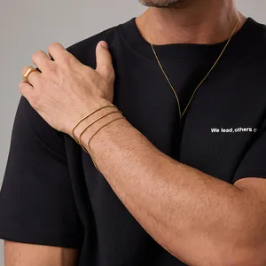 Primo piano di braccialetti a catena serpente dorati e anello a sigillo d'oro