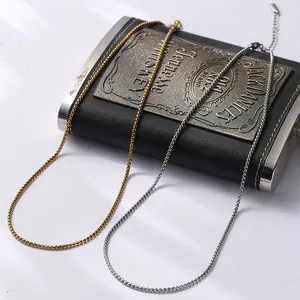 Détail de chaînes box en or et argent vintage sur une flasque en cuir noir
