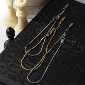 Dettaglio di bracciali a catena a serpente regolabili in oro e argento con chiusura a moschettone