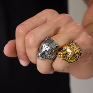 Macro detail of silver and gold stainless steel tiger head rings with embossed textures