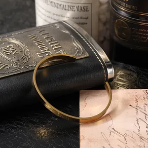 Close-up of a minimalist gold cuff bracelet with high-polish finish on a vintage background