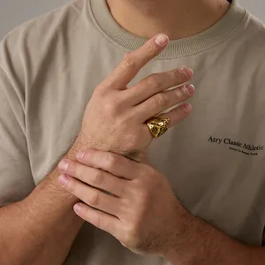 Dettaglio macro di un anello a testa di tigre 3D dorato con rilievo sulla mano