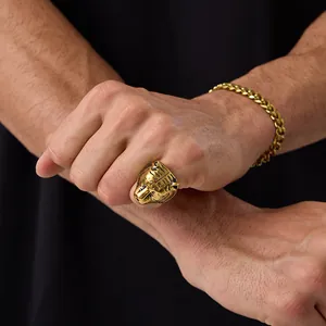 Close-up of golden tiger head relief ring and matching cuban link bracelet on hand