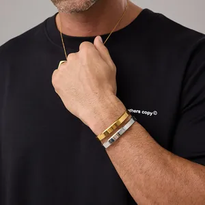 Detailed view of minimalist gold and silver open bangles on model with geometric facets