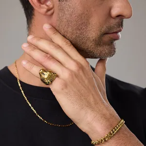 Detailed relief of a golden tiger head ring on male hand with cuban chain bracelet