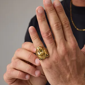 Detailed relief of a golden Egyptian cobra head on a vintage stainless steel ring