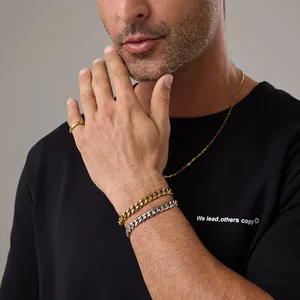 Dettaglio dei bracciali a maglia cubana in oro e argento con anello coordinato su un modello