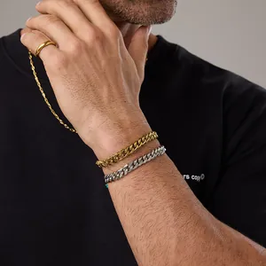 Primo piano di un modello con bracciali a catena in oro e argento e un anello minimale