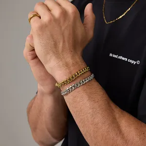 Dettaglio dei bracciali a maglia cubana oro e argento che mostrano la lucentezza del metallo