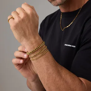 Bracciali a catena cubana placcati in oro e anello minimalista da uomo su un modello