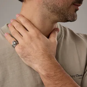 Detail of vintage wolf head stainless steel ring worn on model's finger for men