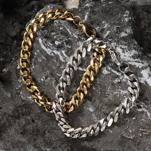 Dettaglio di bracciali a catena cubana oro e argento con chiusura a moschettone su roccia