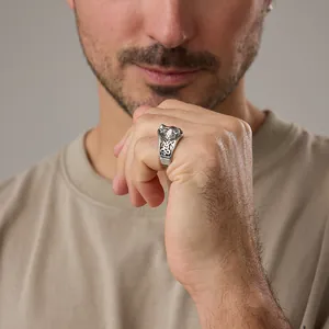 Close-up of vintage steel wolf head ring with intricate Celtic knot engraving