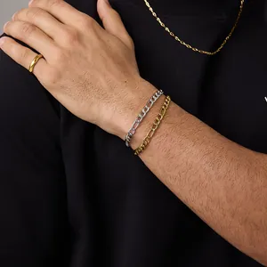Gros plan de bracelets Figaro en or et argent portés par un mannequin homme sur fond noir