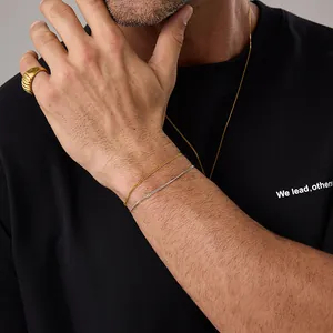Model wearing minimalist 18K gold and silver curb chain bracelets with textured ring
