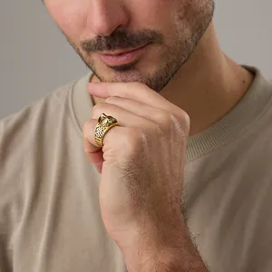 Detail of vintage wolf head ring in gold finish with Celtic knot patterns on male hand