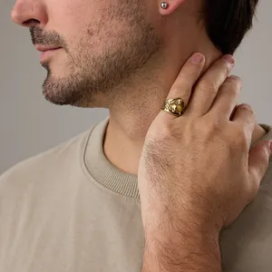 Detail of vintage gold wolf head signet ring worn on a finger for a bold street style look