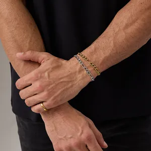 Gros plan de chaînes Figaro or et argent et d'une bague dorée irrégulière sur un mannequin
