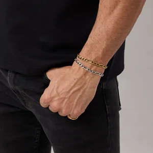 Gros plan de bracelets Figaro en or et argent portés au poignet pour un look superposé