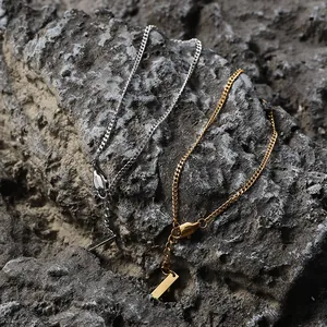 Detail view of gold and silver Cuban chain bracelets with lobster clasp on rock background