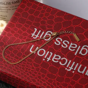 Detailed macro view of an 18K gold Cuban link bracelet with lobster clasp and tag