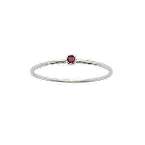 Minimalistischer Edelstahlring mit rundem rotem Zirkon in Zargenfassung auf Weiß