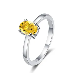 Dettaglio di un anello in moissanite gialla ovale con montatura in argento lucido a quattro griffe