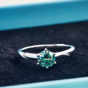 Detailed view of a green round cut moissanite silver ring in a blue velvet jewelry box