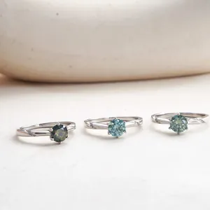 Detailed macro view of three 1 carat moissanite rings in green and blue hues on S925 silver