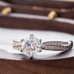 Detail of six-prong moissanite ring with double-row micro-pave diamonds on silver band