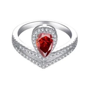 Close-up of pear-shaped pink moissanite ring with a V-shaped pavé-set silver band