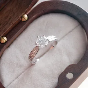 Macro view of a moissanite ring featuring a six-prong setting and side stone accents