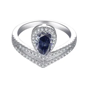 Elegant silver crown ring with a large pear-cut deep blue gemstone and V-shaped band