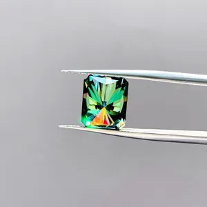 Macro-opname van een stralend geslepen blauwgroene moissaniet met pincet en vuur