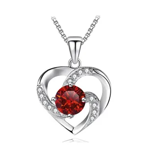 Detailed close-up of heart pendant with red center stone and silver box chain