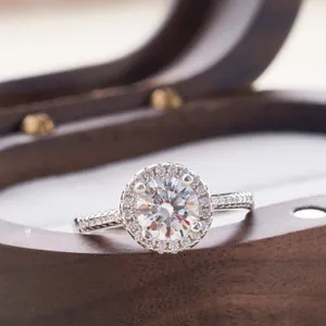Macro-opname van zilveren halo ring met grote moissanite steen op een houten doos