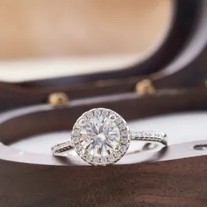 Macro-opname van zilveren Moissanite ring met ronde halo zetting en pavé details op de band