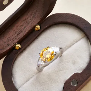Detailed macro view of silver ring with yellow round center stone and pear side gems