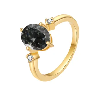 Macro view of 18K gold ring with oval black moissanite and two small side stones