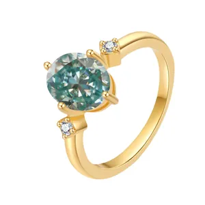 Close-up of 18K gold ring with 2ct oval teal moissanite and side diamond details
