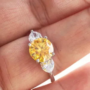 Macro shot of 3-carat yellow moissanite ring with pear-cut side stones in silver band