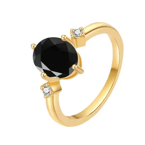 Macro shot of 18K gold ring featuring an oval black gemstone and sparkling side stones