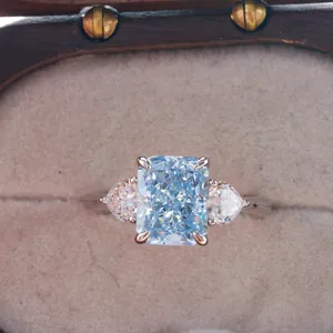 Macro view of a 3-carat radiant cut blue gemstone ring with pear-shaped side stones