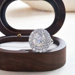 Gros plan d'une bague en moissanite avec double halo posée sur un coffret à bijoux