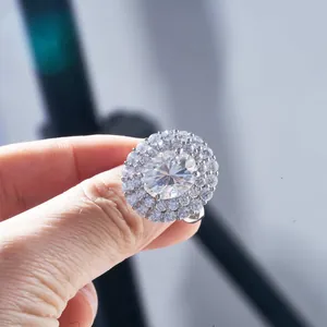 Vue macro d'une bague moissanite ovale de luxe avec double halo sur la main