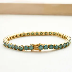 Détail d'un bracelet tennis en argent 925 avec moissanite vert foncé et placage en or