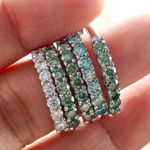 Macro shot of 925 silver eternity rings with 3mm white and teal moissanite stones