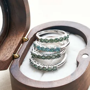 Macro detail of four S925 sterling silver rings with green moissanite in a heart wood box